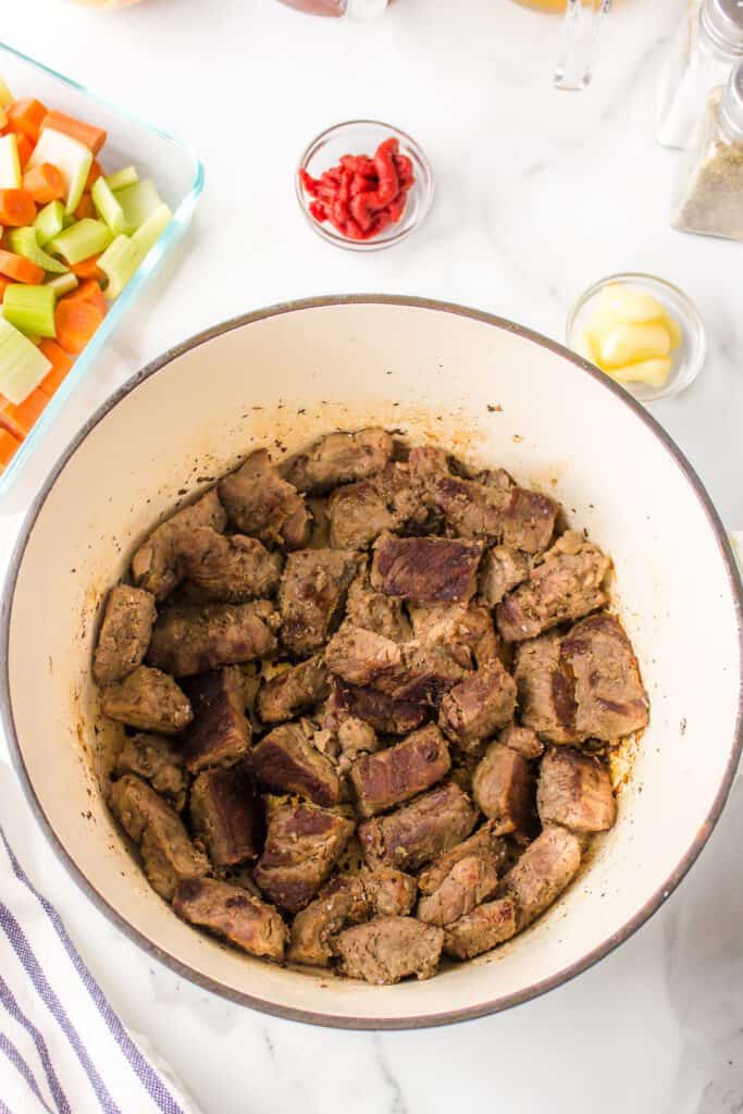 Seared stew meat in a pot.