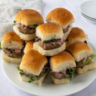 A plate of ground turkey sliders stacked on a plate.