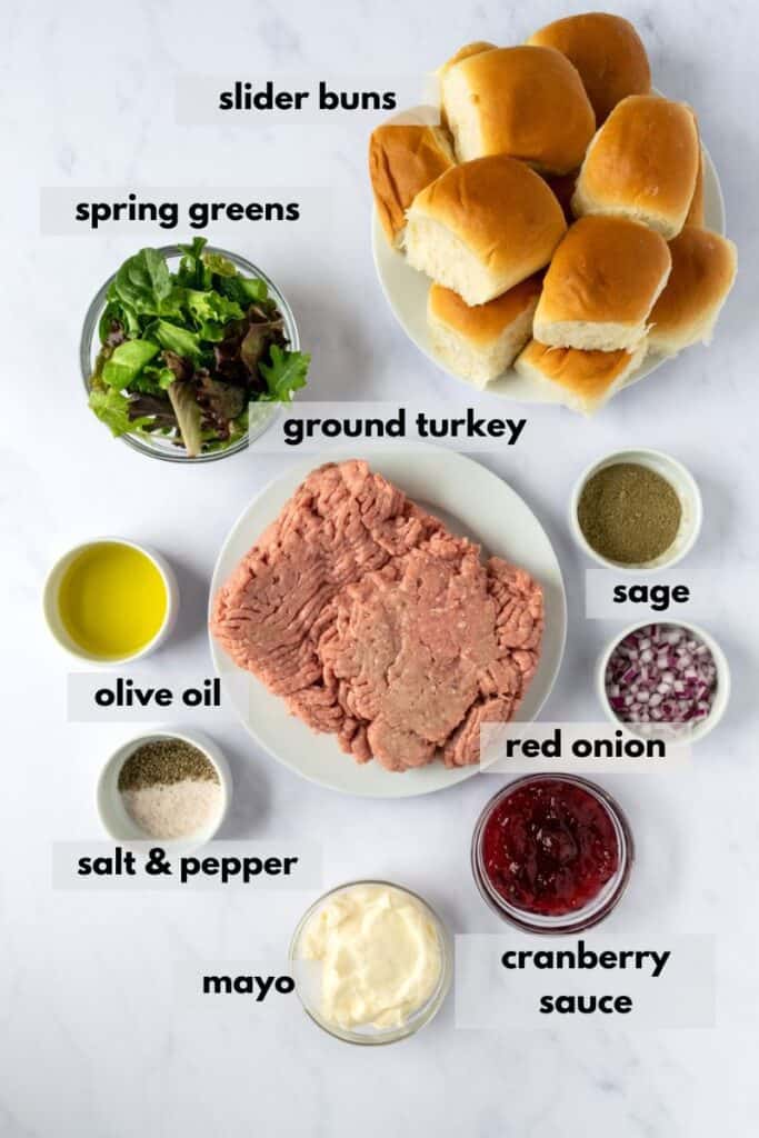Ingredients in ground turkey sliders include slider buns, sage, spring greens, olive oil, salt, pepper, mayo, cranberry sauce, red onion and turkey.