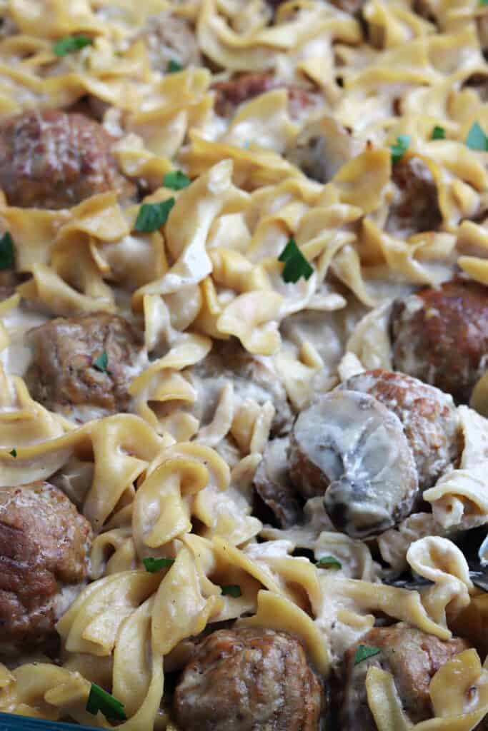 Close up of Swedish meatballs and sliced mushrooms with egg noodles.