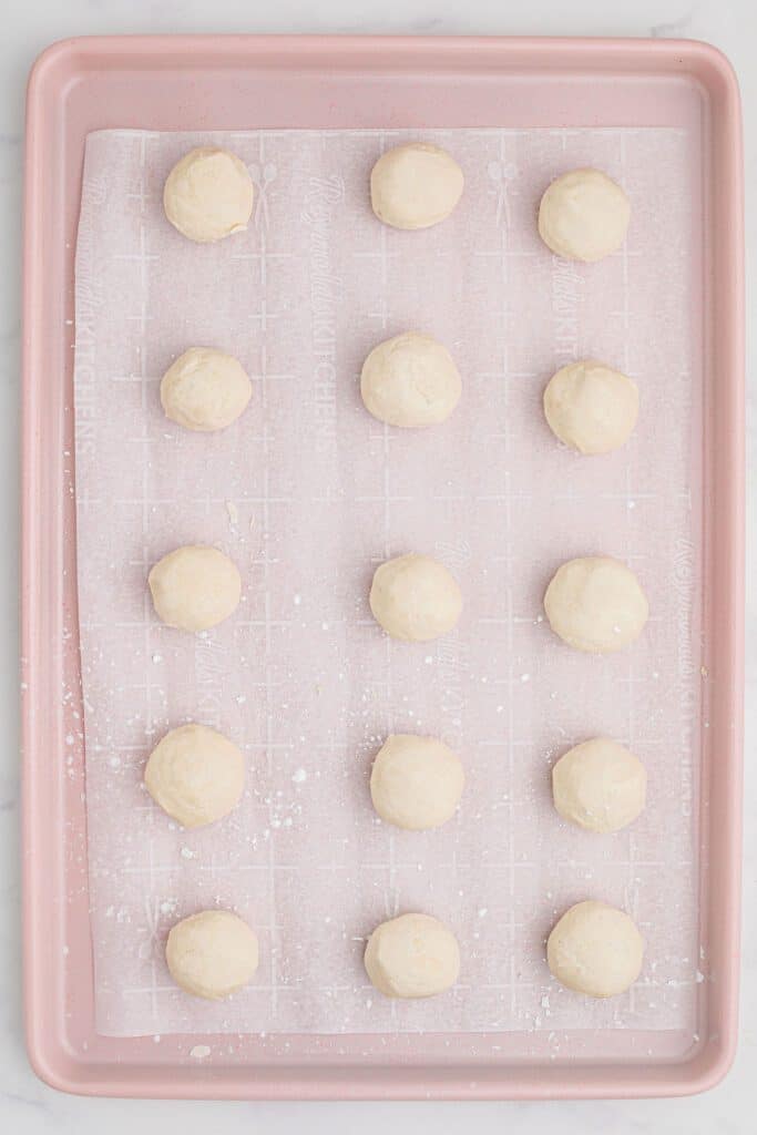 Shortbread cookie dough in balls on a cookie sheet.