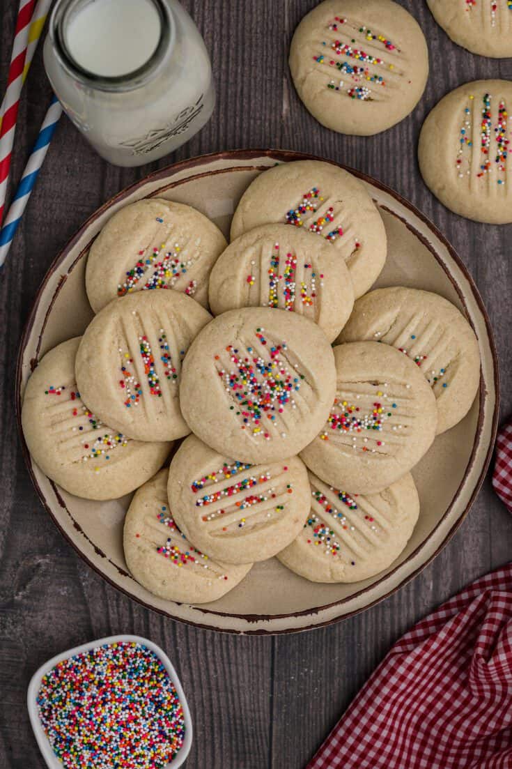 A plate of shortbread cookies with sprinkles.