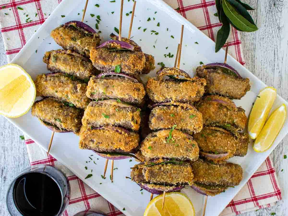 A plate of spiedini with lemon slices.