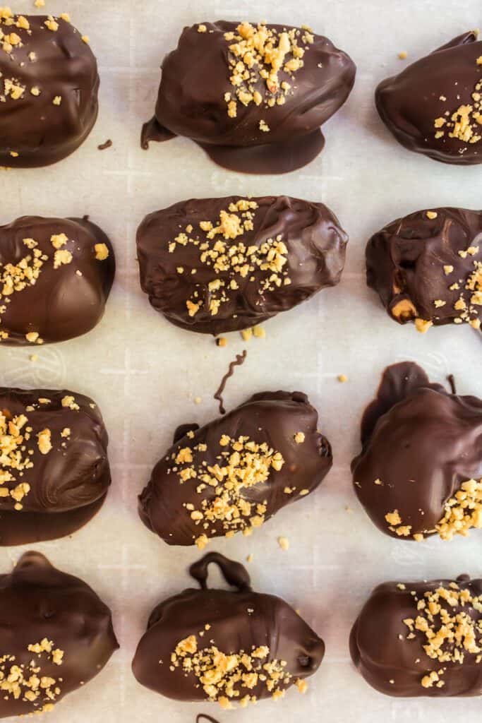 Peanut butter stuffed dates coated in chocolate and topped with chopped peanuts.