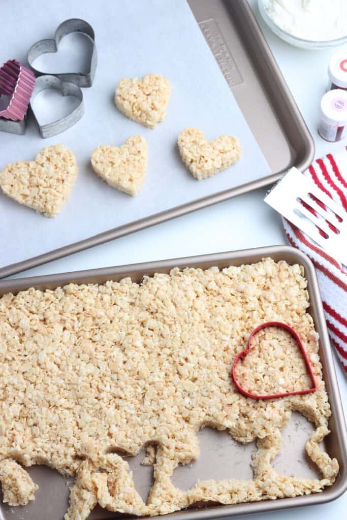 A cookie sheet with rice krispie treat mixture spread throughout.