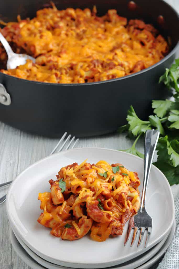 Macaroni noodles with ground beef, cheese, tomato sauce and spices on a plate.