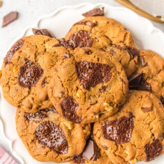 A plate of dark chocolate and chocolate chip cookies with walnuts.