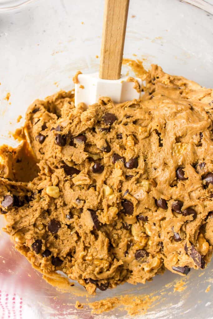 Folding dark chocolate and chocolate chips into the cookie batter.
