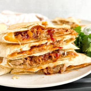 Stacked quesadillas with shredded pork, melted cheese and barbecue sauce.