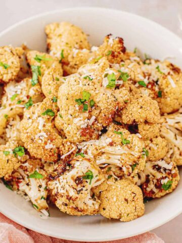 A bowl of air fryer cauliflower topped with parmesan cheese.