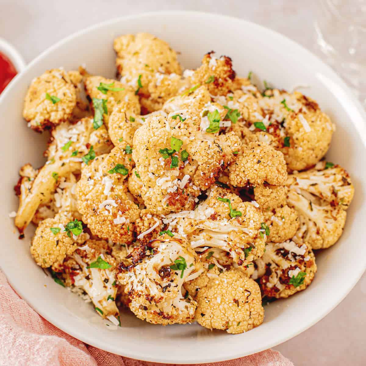 A bowl of air fryer cauliflower topped with parmesan cheese.