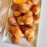 Bite sized soft pretzel bites on a white platter.
