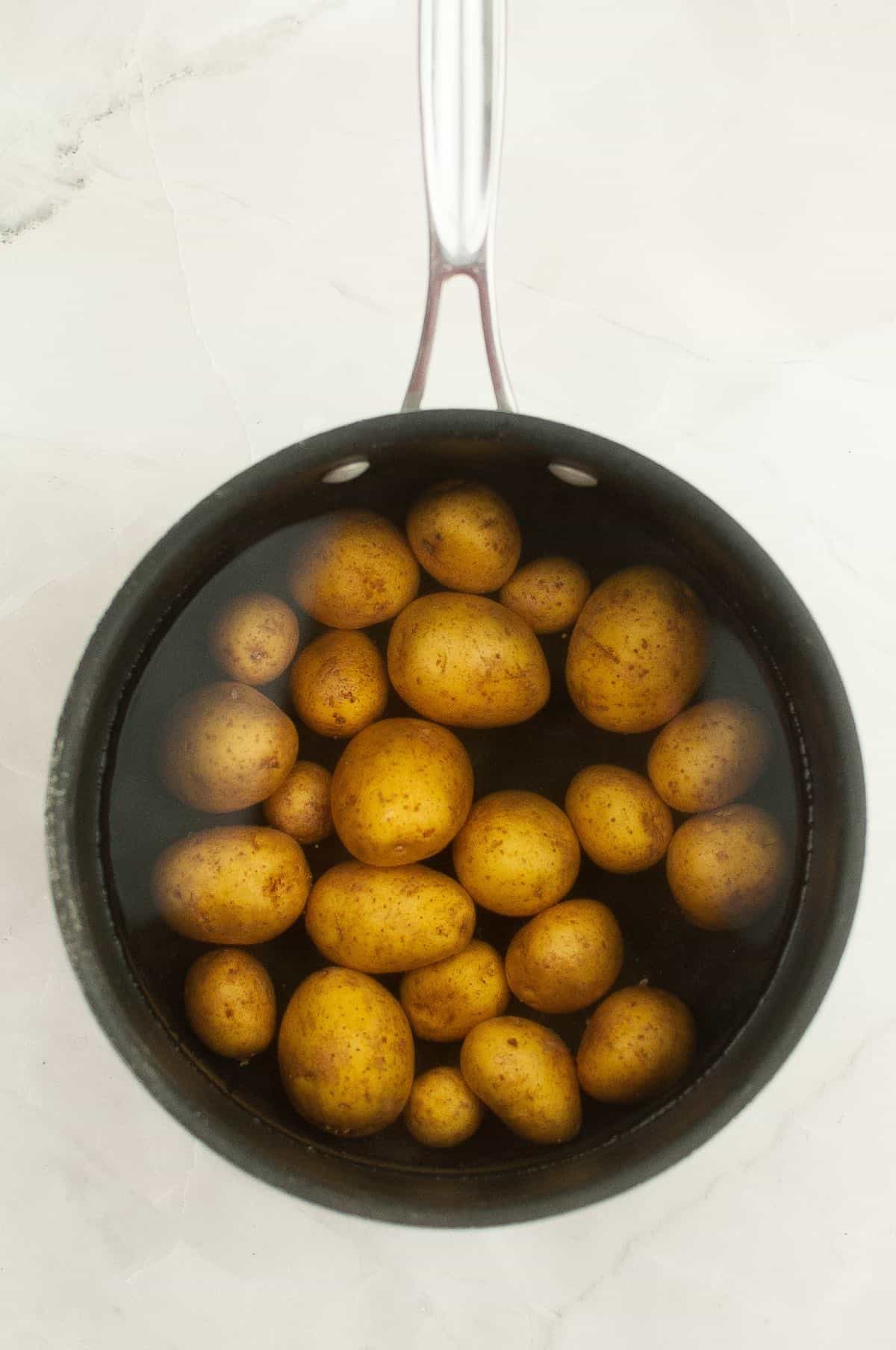 Cooking baby potatoes in water.