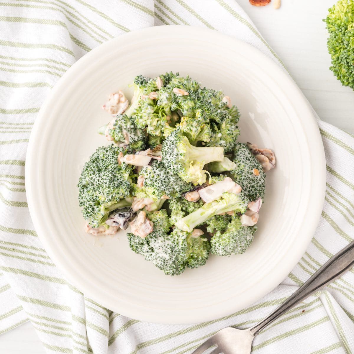 The best broccoli crunch salad in a bowl with a fork alongside it.