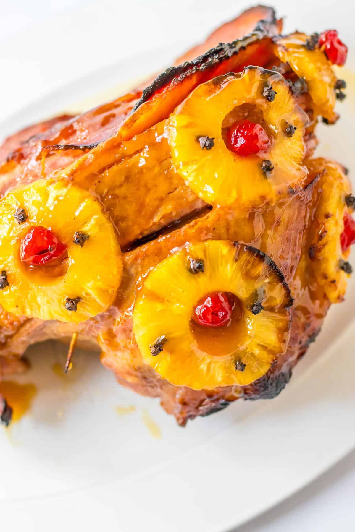 Cooked spiral ham with pineapple and cherries.