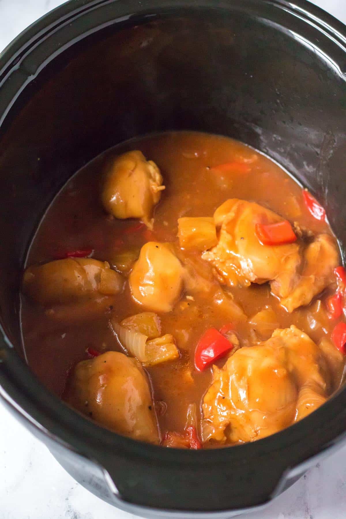 Cooked chicken, pineapple and peppers in the slow cooker.