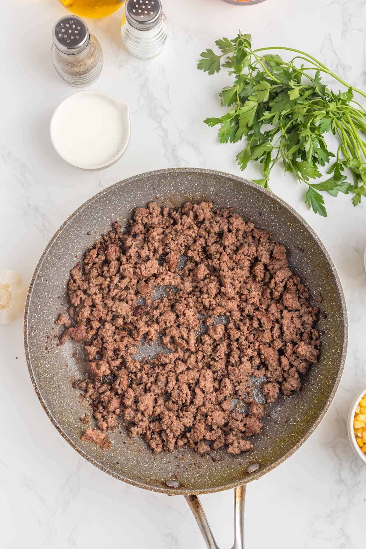 Cooked ground beef in a skillet.