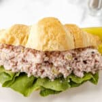 Ham salad on a croissant with lettuce.