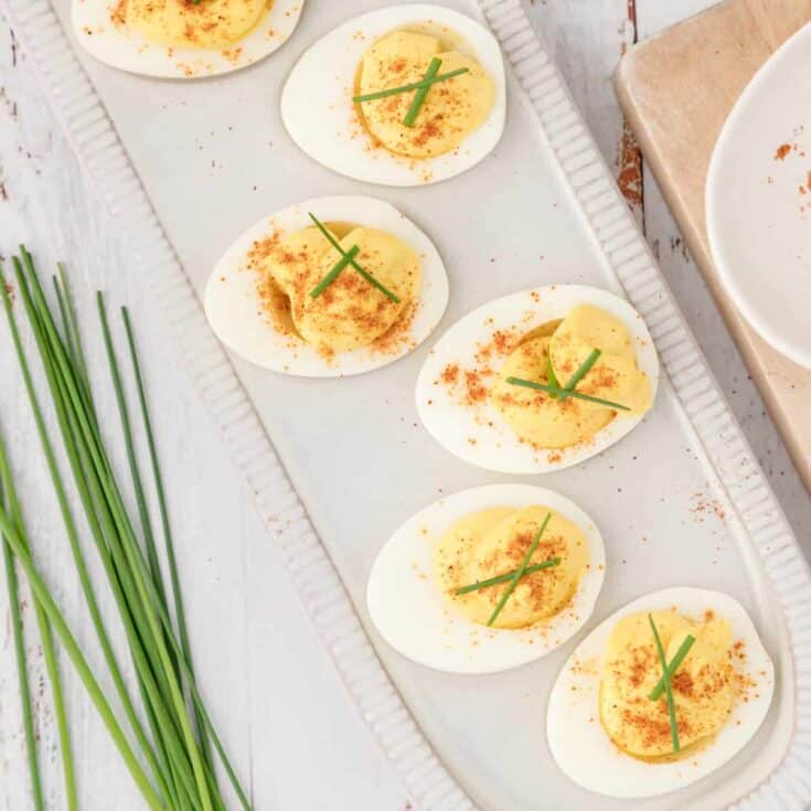 Platter of six deviled eggs topped with snipped chives.