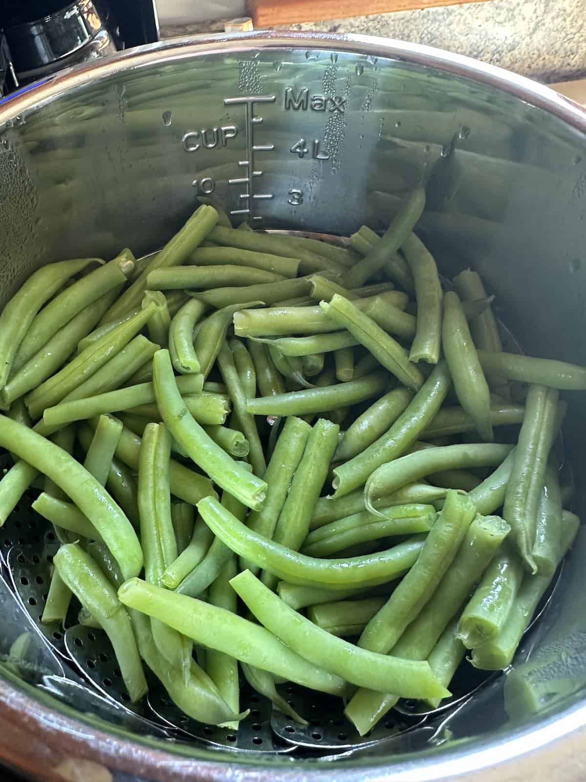 Cooked green beans in a pot after cooking.