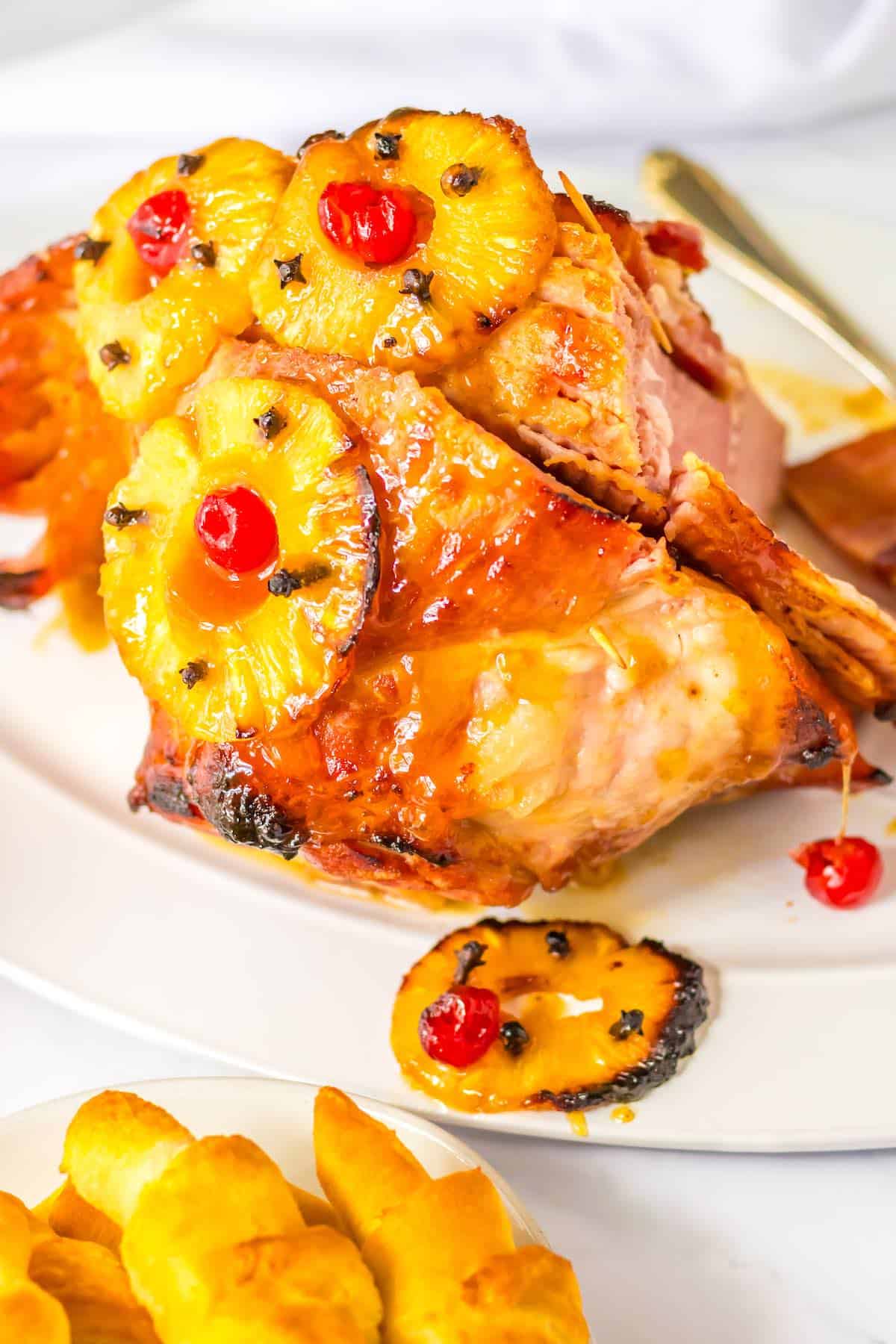 A cherry, pineapple and honey glazed ham on a platter.