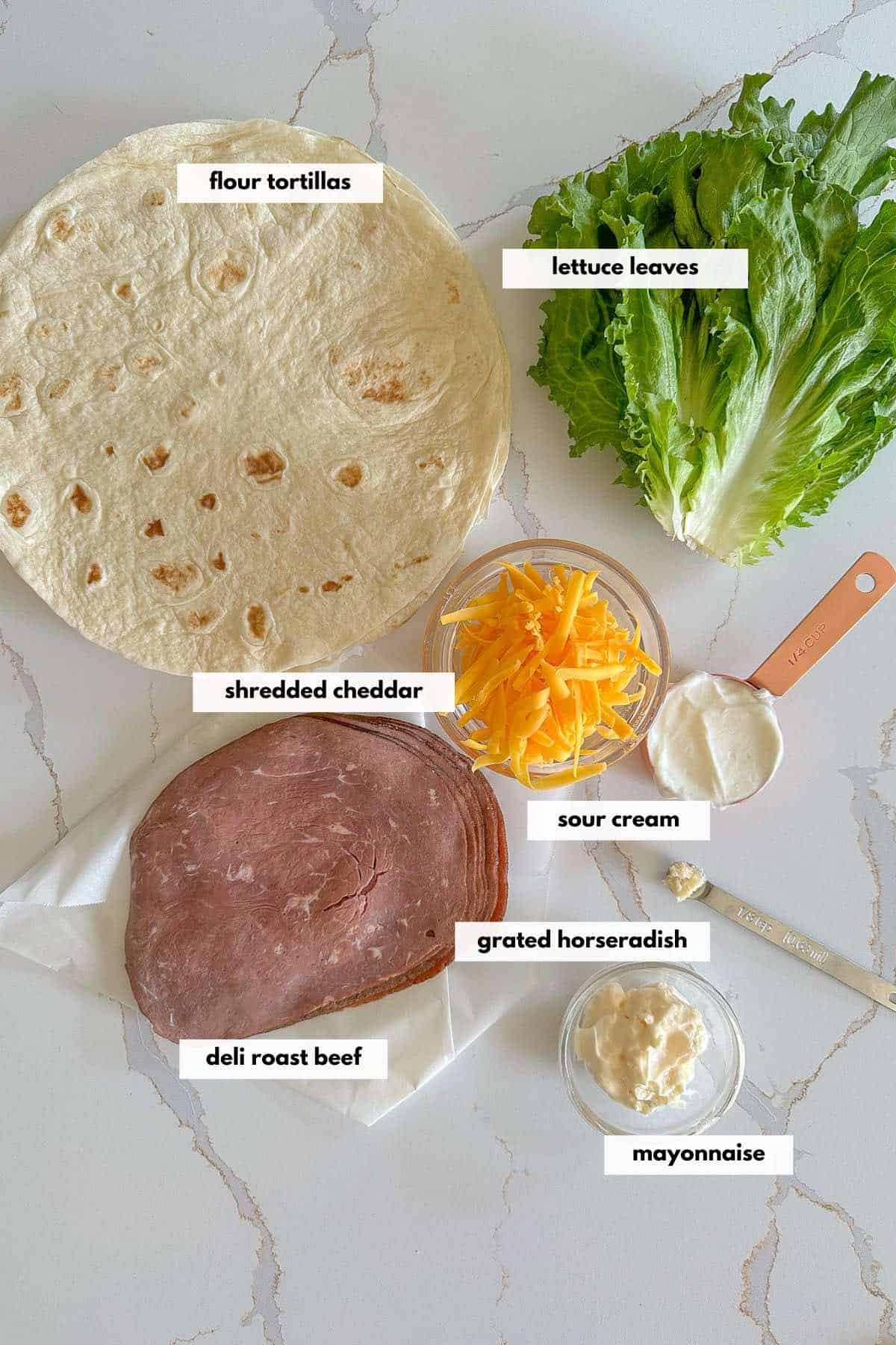 Ingredients to make this recipe are deli roast beef, shredded cheddar cheese, lettuce leaves, flour tortillas, grated horseradish, sour cream and mayonnaise.
