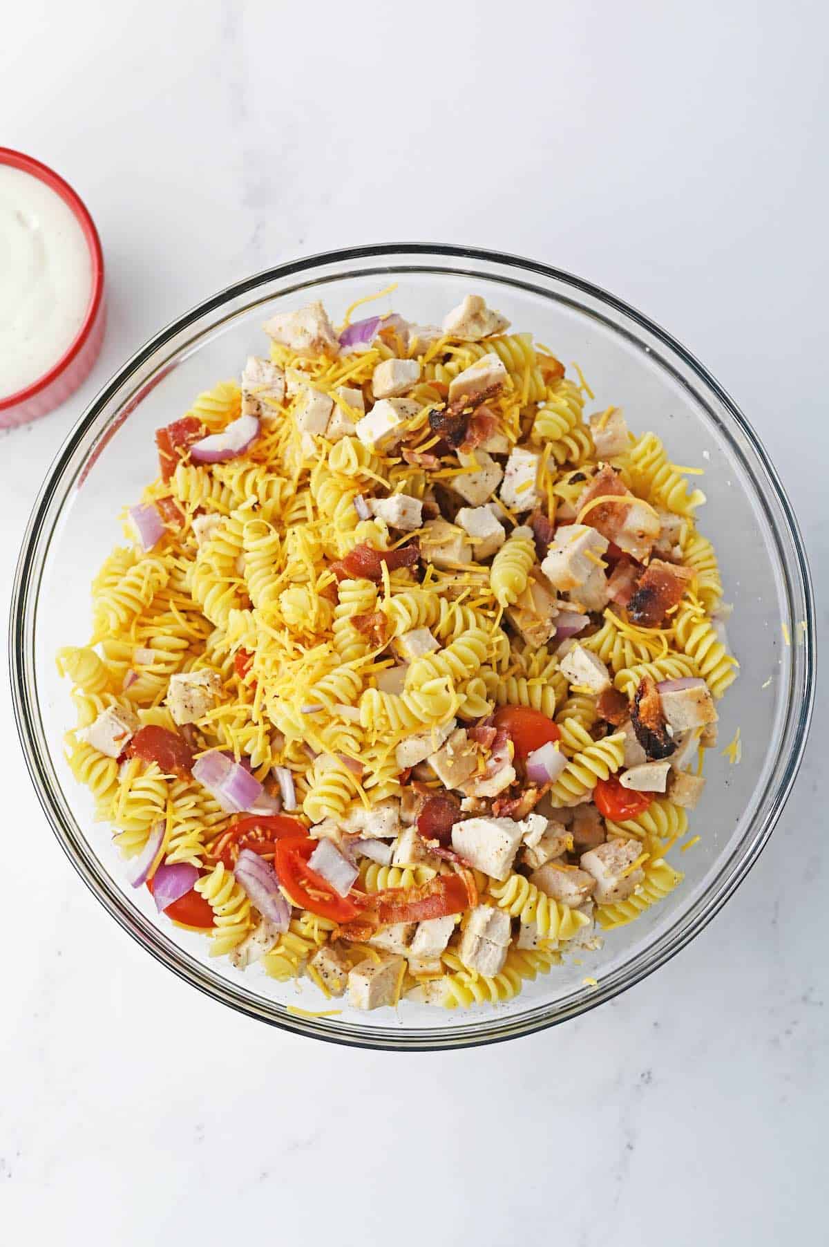 Rotini pasta tossed with tomatoes, bacon, red onion.