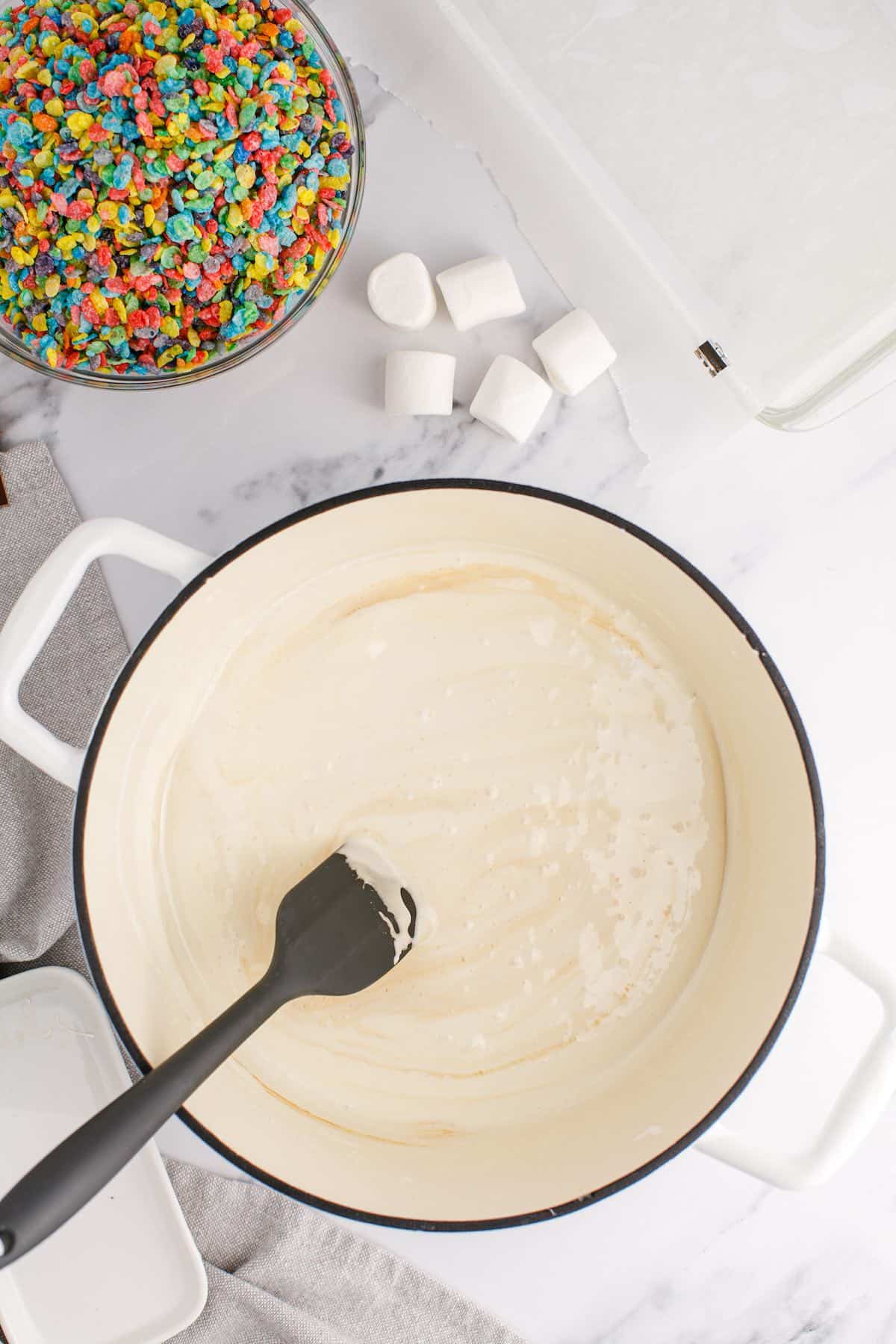 A mixture of melted butter, marshmallows and vanilla extract stirred until smooth in a pot.