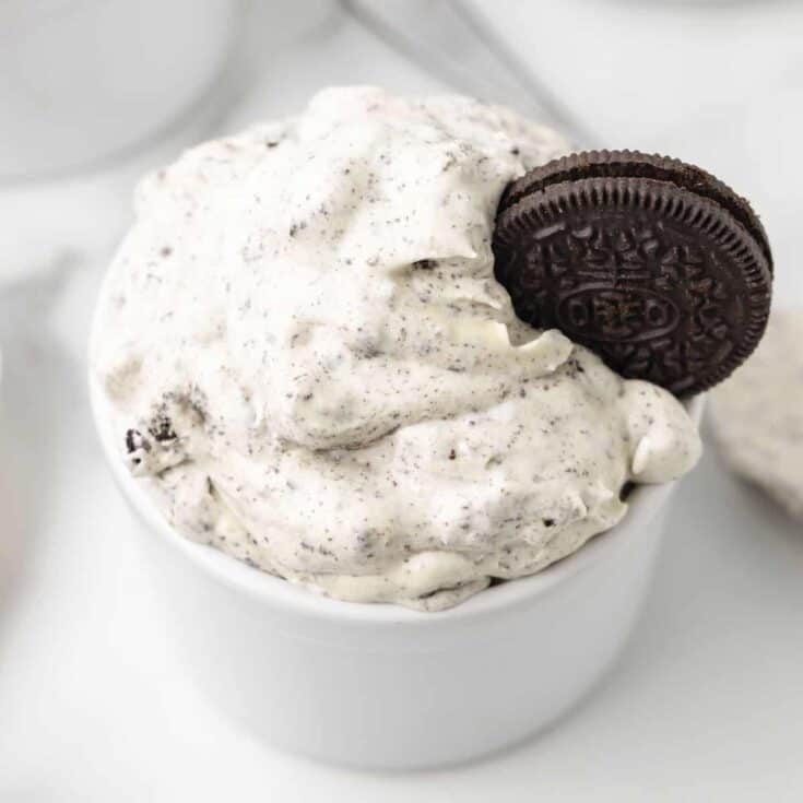 A bowl of creamy Oreo fluff topped with an oreo cookie.