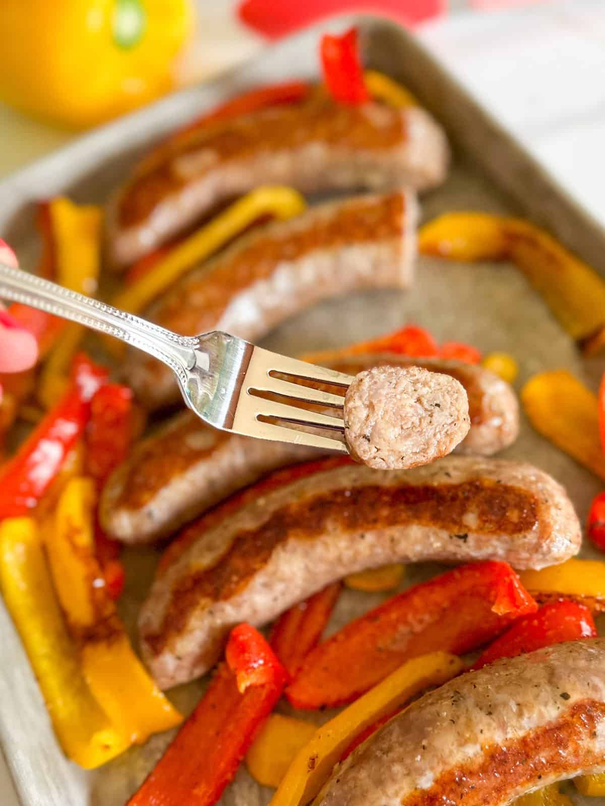 A bite of juicy Italian sausage on a fork.