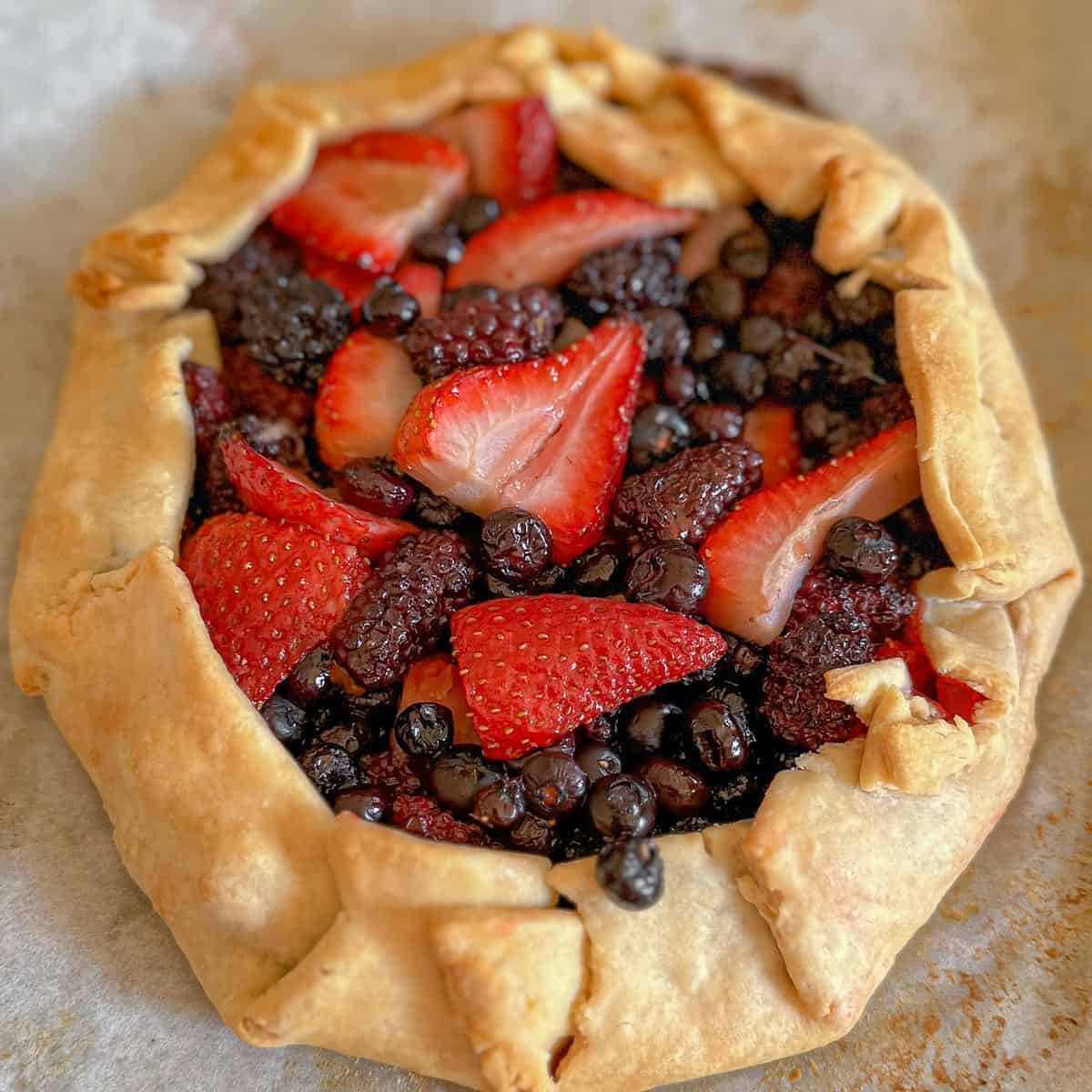 A mixed berry galette with raspberries, blueberries and blackberries after baking.