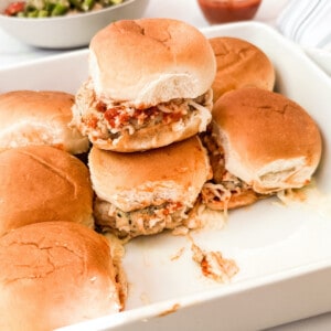 Pan of stacked chicken parmesan sliders.