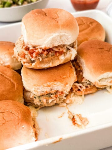 Pan of stacked chicken parmesan sliders.