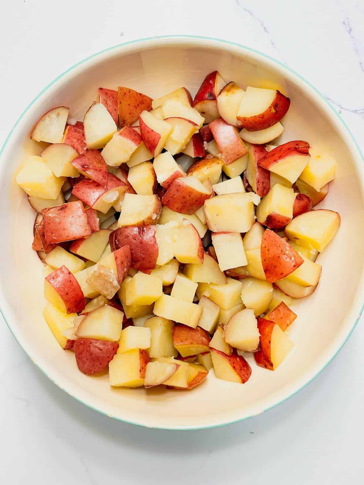 Cooked and chopped red potatoes in a bowl.