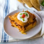 Cheesy cowboy cornbread casserole topped with a dollop of sour cream.