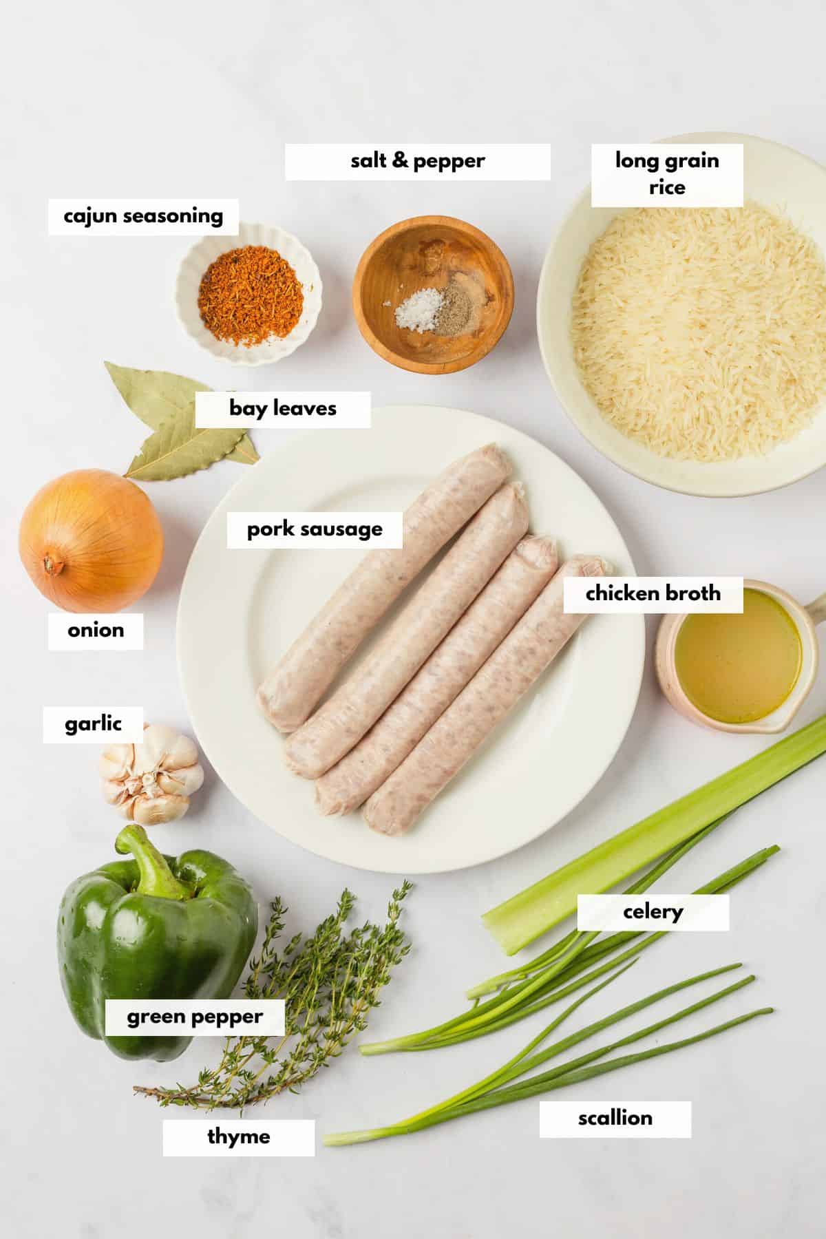 Ingredients to make Cajun dirty rice with sausage including pork sausage, green peppers, onion, garlic, cajun seasoning, long grain white rice, thyme, broth and scallions.