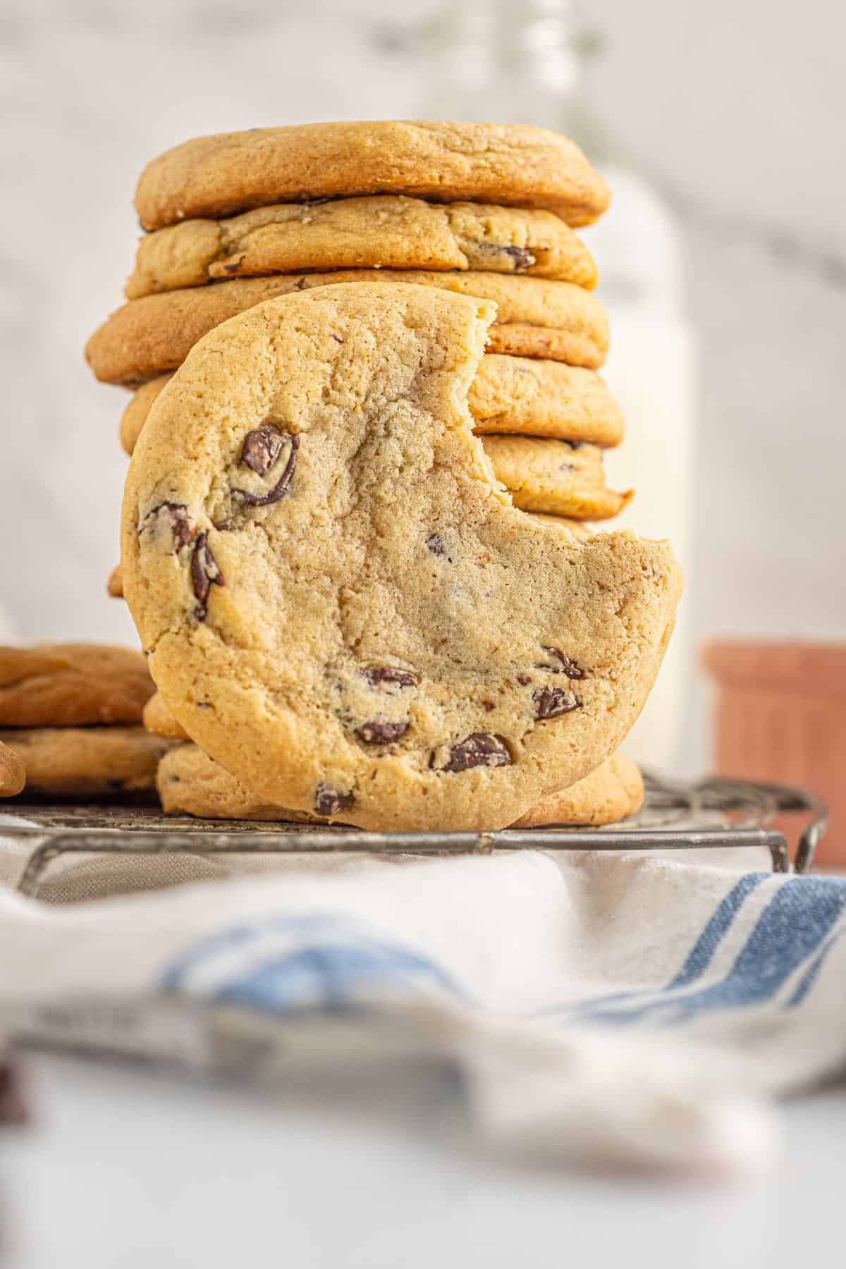 A stack of chocolate chip cookies with a bite out of one.