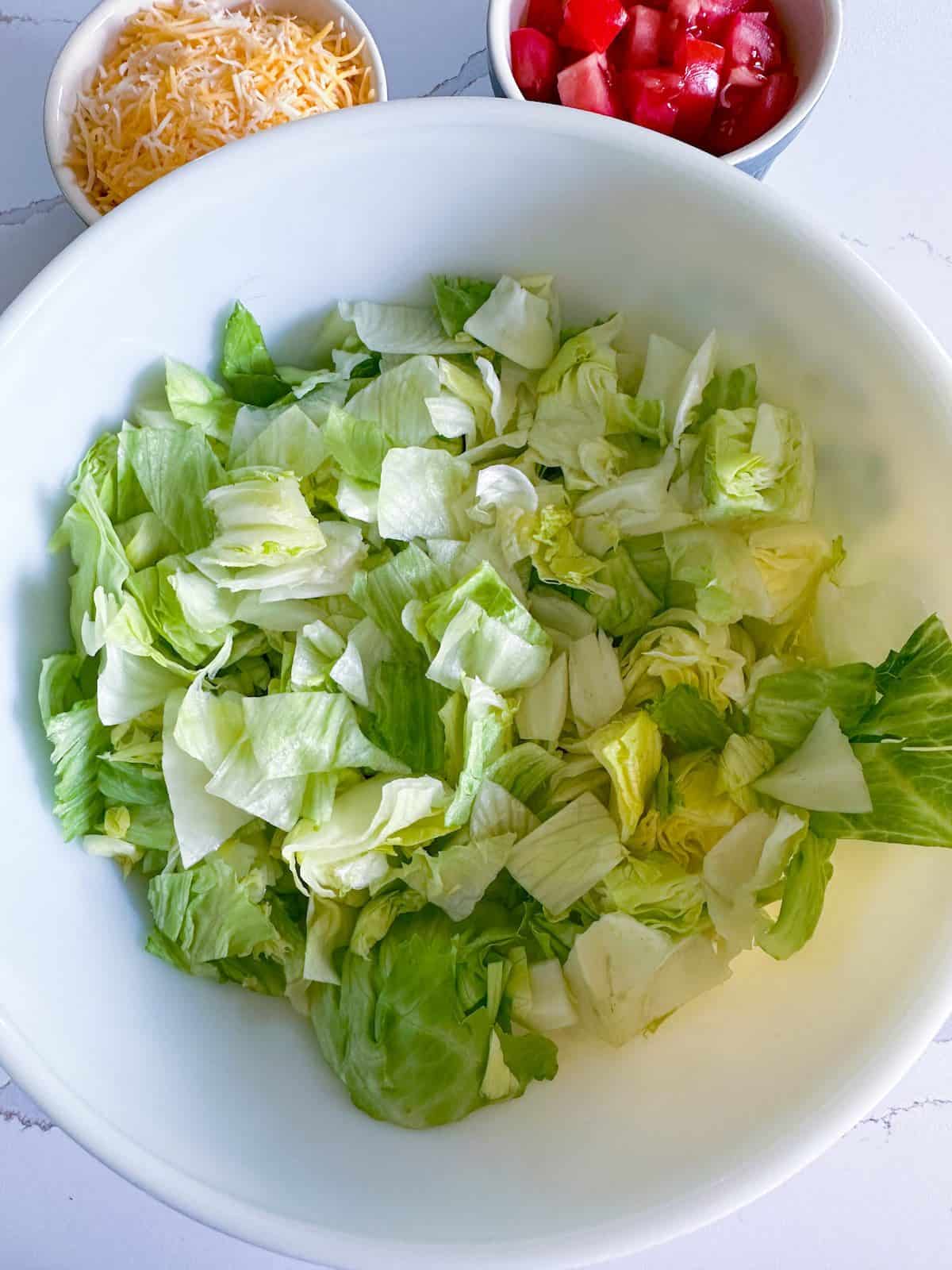 Chopped iceberg lettuce in a large salad bowl.