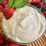 Marshmallow fluff fruit dip topped with a fresh strawberry and mint leaves.