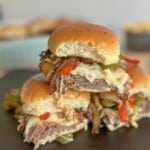 Stacked sliders with cheese, bell peppers and roast beef.
