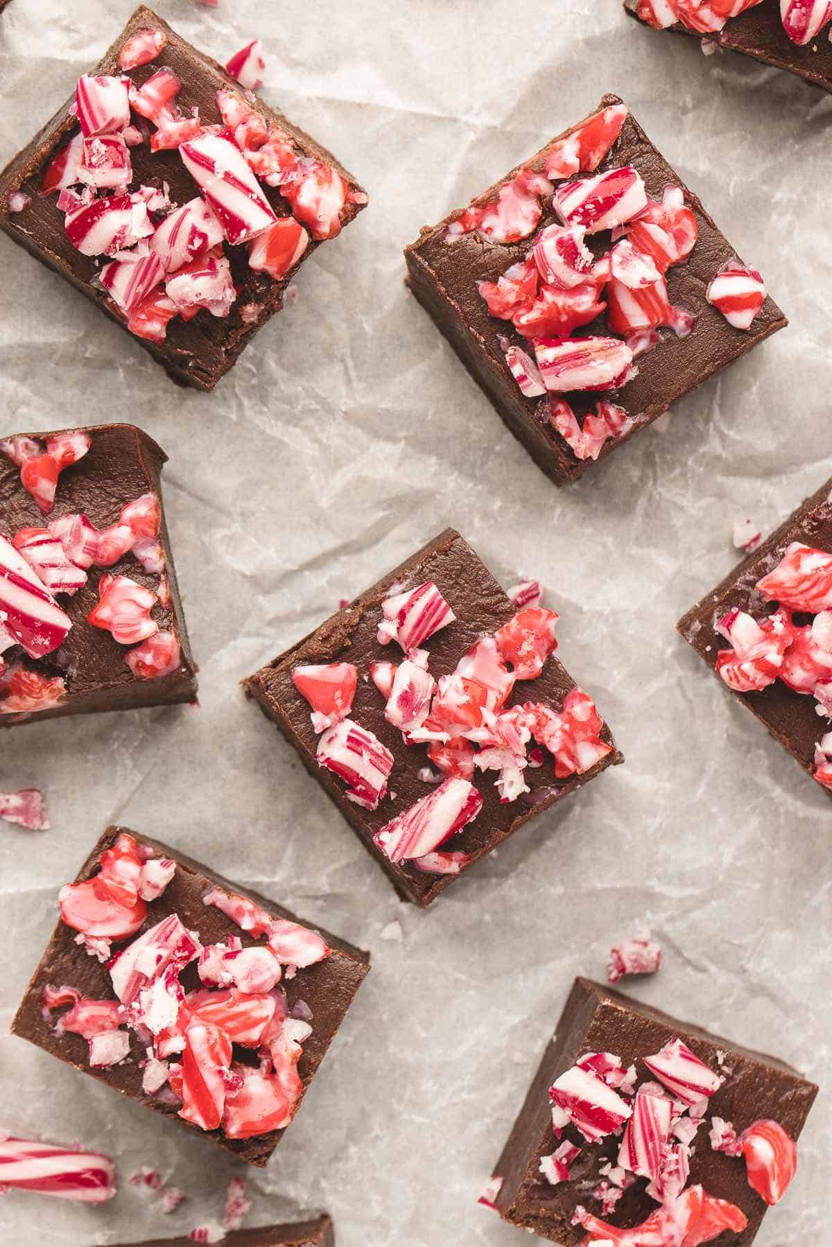 Squares of a peppermint fudge recipe topped with candy cane pieces.