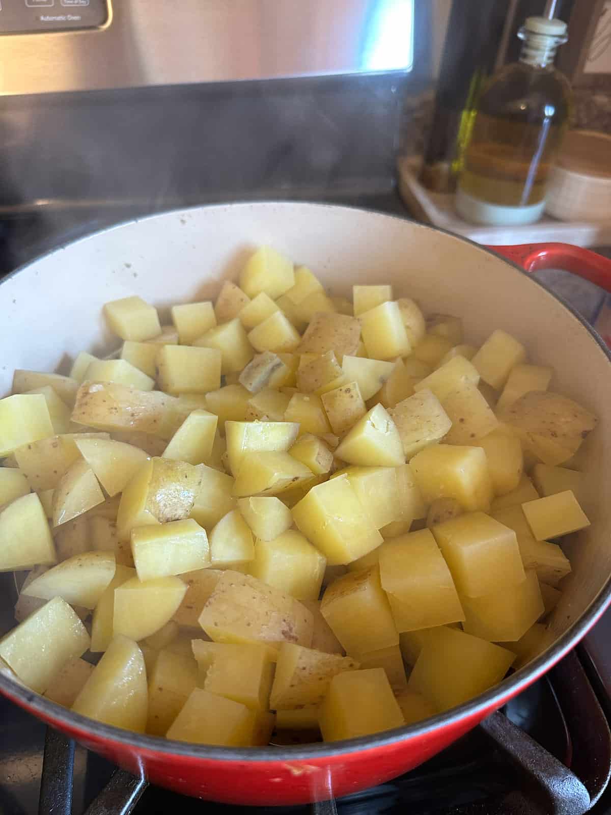 Diced cooked potatoes in a pot on the stove.