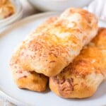 A stack of baked dough logs sitting on a plate.