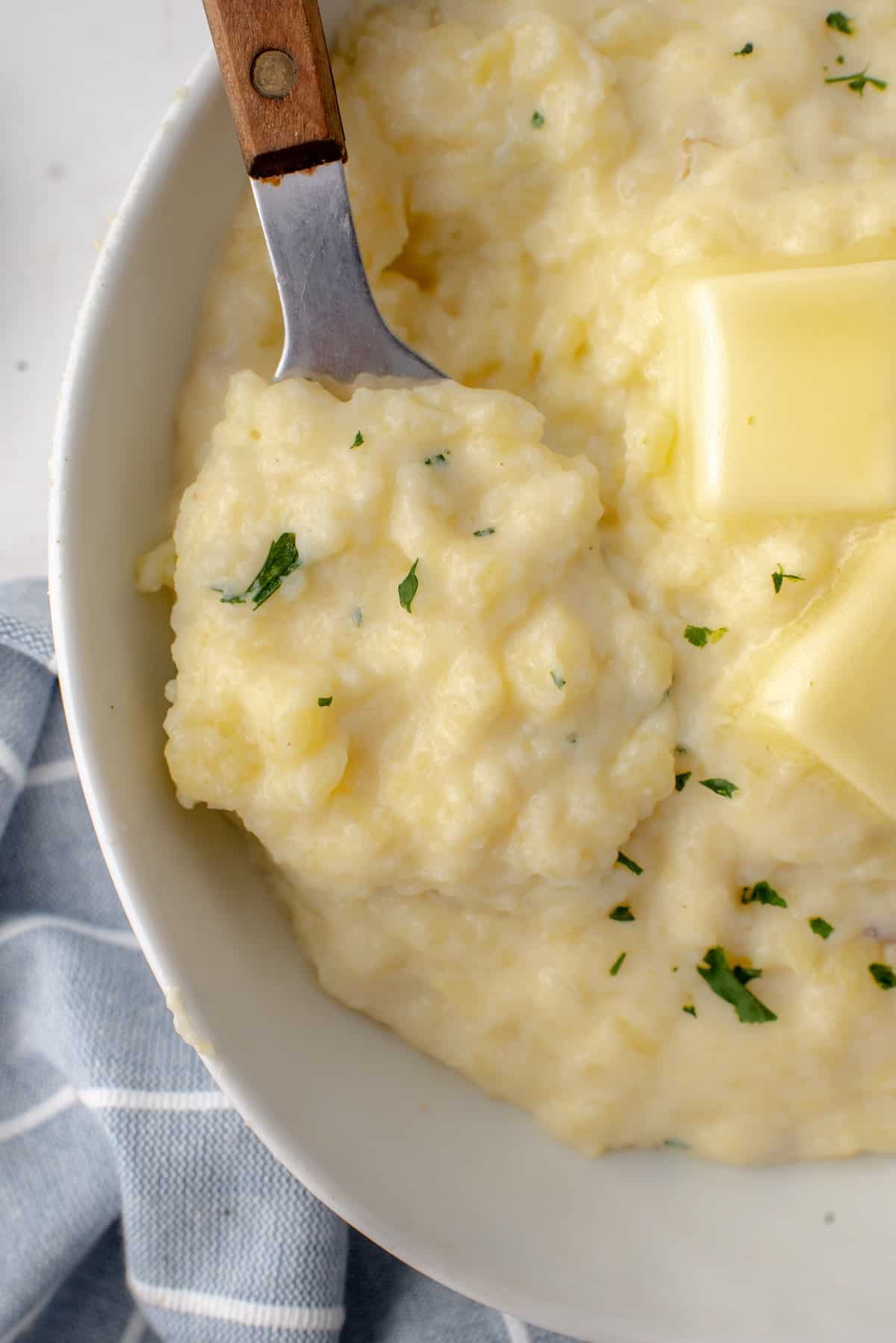 A bowl of no drain mashed potatoes with a serving spoon.