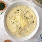 Mashed potatoes in a bowl topped with butter.