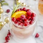 No alcohol Christmas punch topped with cranberries and an orange slice.