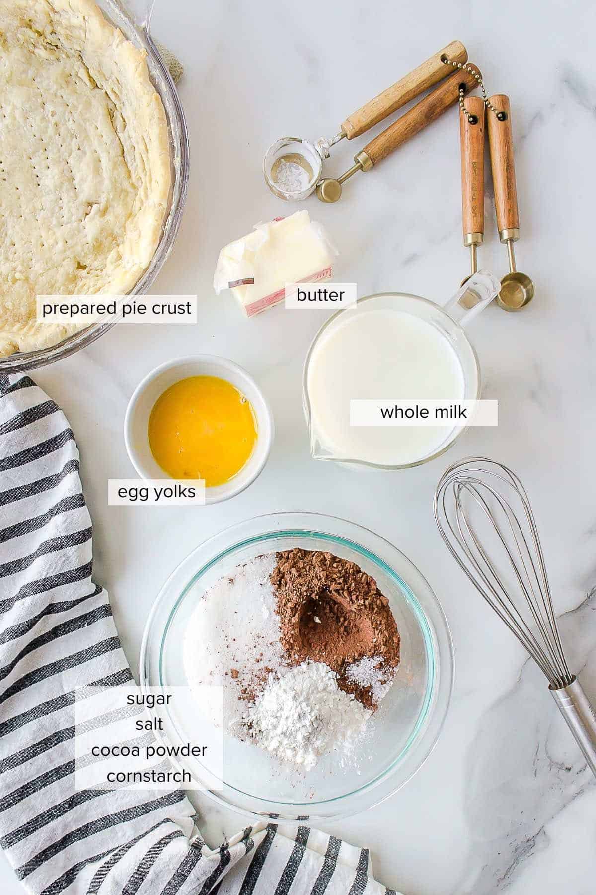 Ingredients to make a chocolate pie with prebaked pie crust, whole milk, eggs, sugar, salt, cocoa powder, cornstarch and butter.