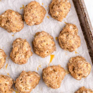Baked sausage balls on a sheet pan lined with parchment paper.