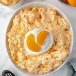 Creamy orange fluff salad is made with jello, whipped topping, and mandarin oranges.
