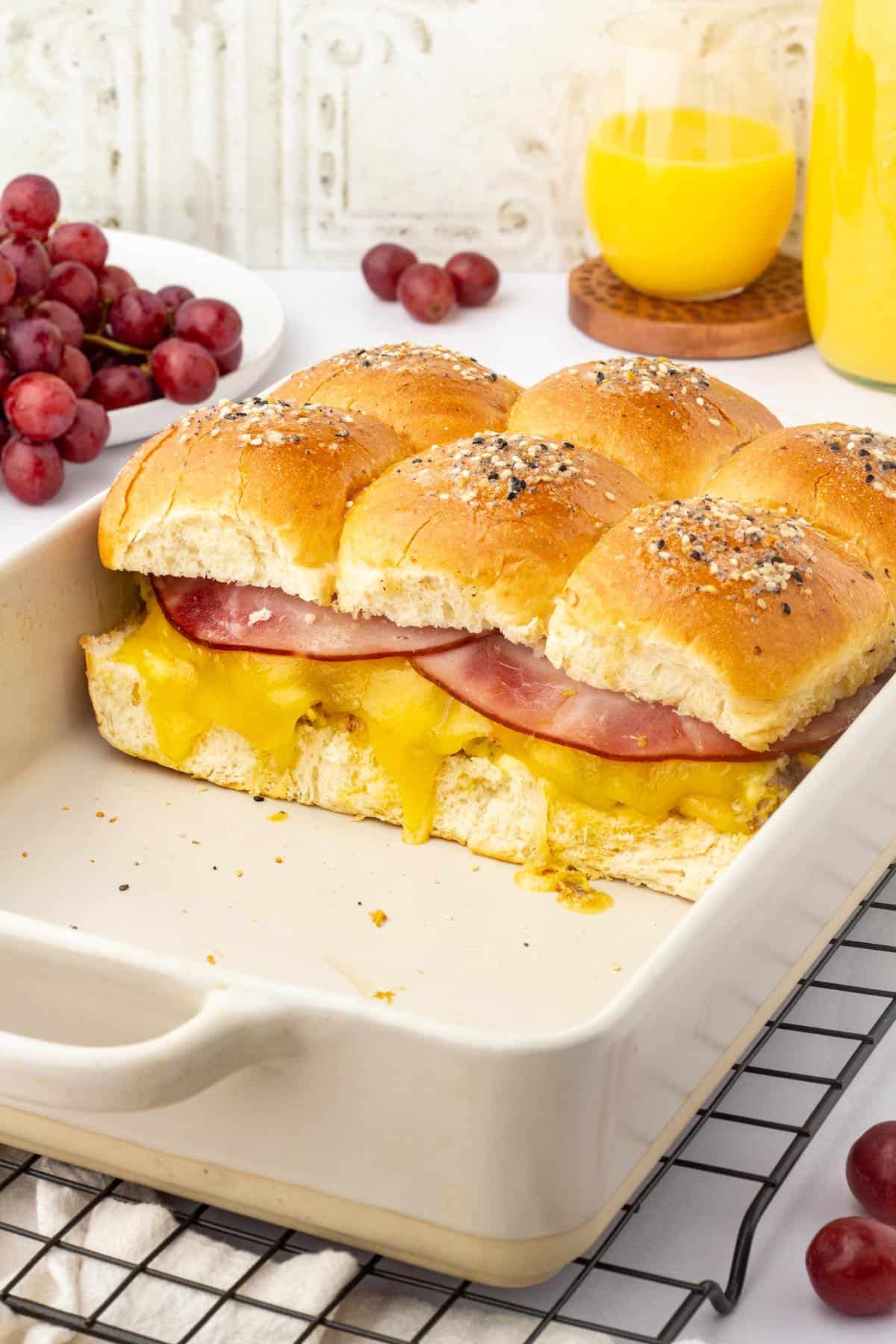 A casserole dish showing ham, cheese and sausage breakfast sliders.